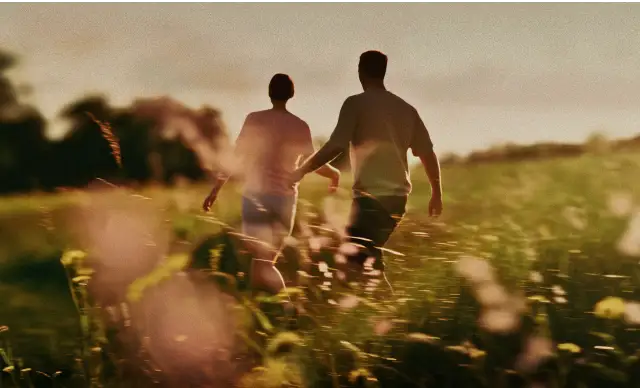 Man and woman walking through a field.