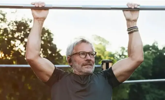 Man outside doing pull-ups.